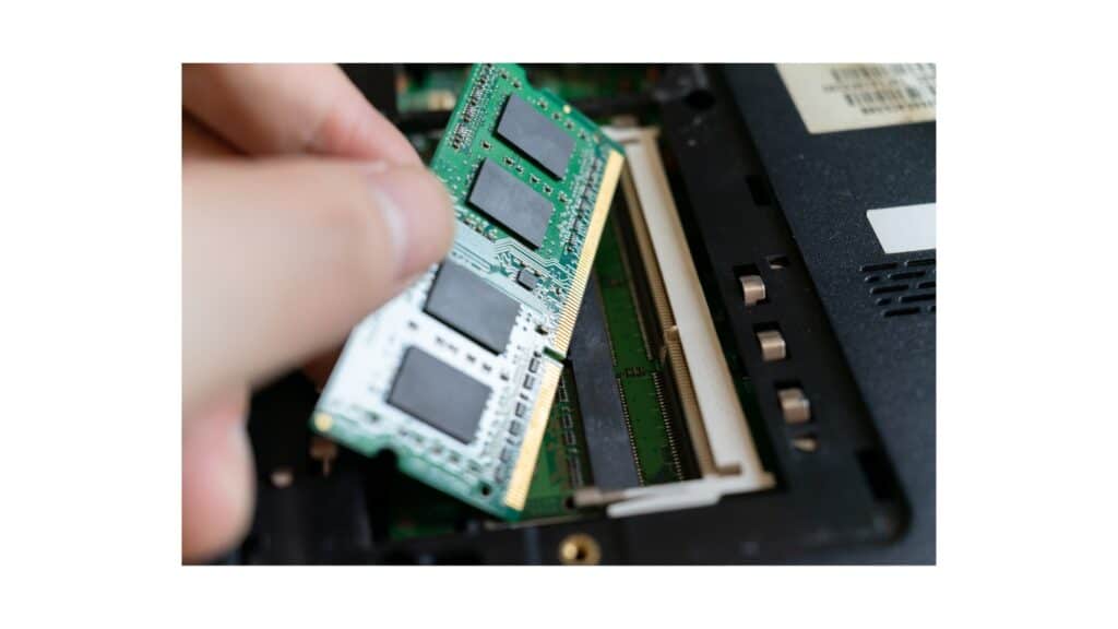 Main insérant une barrette de RAM 16 Go dans un slot d’ordinateur portable